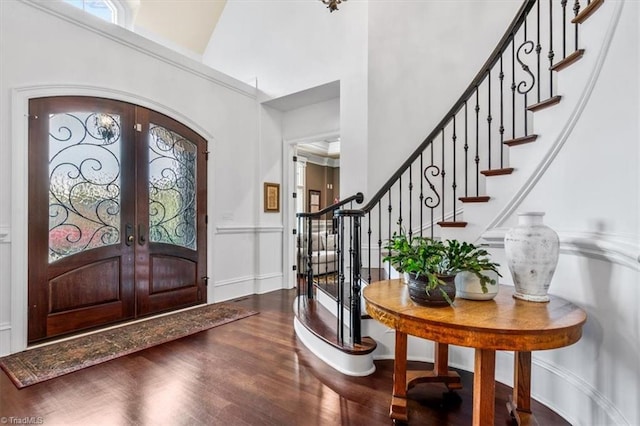 foyer entrance with a high ceiling, french doors, and wood-type flooring