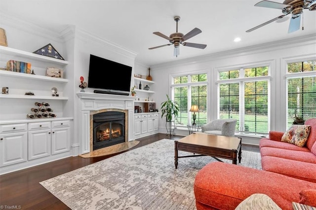 living room with ornamental molding, a fireplace, dark hardwood / wood-style floors, and ceiling fan