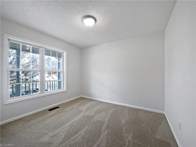 carpeted empty room featuring visible vents and baseboards