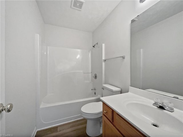 full bathroom with visible vents, toilet, wood finished floors, vanity, and shower / bathtub combination