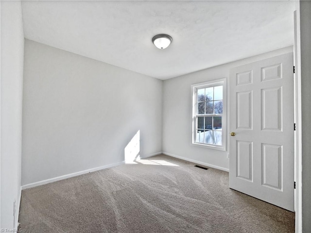 carpeted spare room with baseboards and visible vents