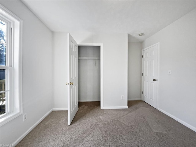 unfurnished bedroom with a closet, baseboards, and carpet flooring