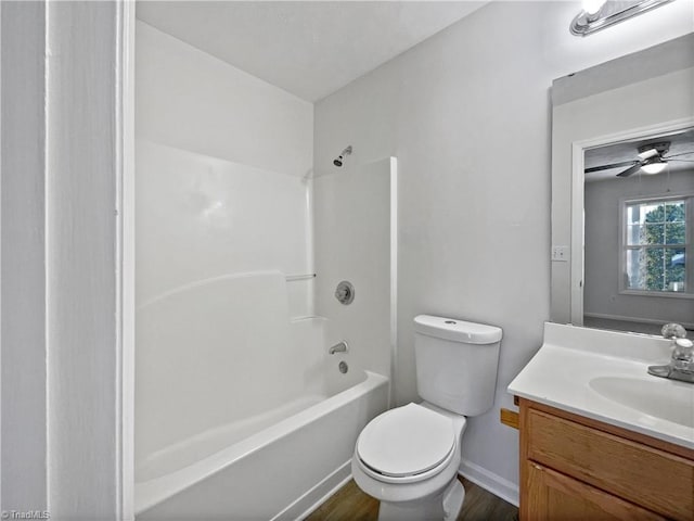 full bath with vanity, wood finished floors, washtub / shower combination, baseboards, and toilet