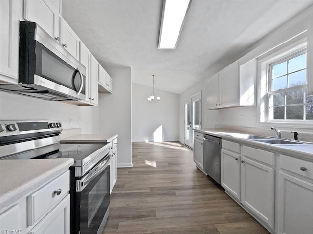 kitchen with a chandelier, appliances with stainless steel finishes, white cabinetry, and light countertops