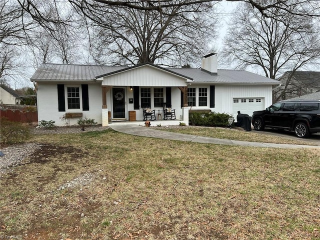 single story home featuring a porch, a front yard, metal roof, a chimney, and an attached garage