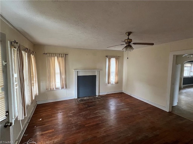 unfurnished living room with ceiling fan, a healthy amount of sunlight, and dark hardwood / wood-style floors