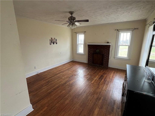 unfurnished living room with a fireplace, a textured ceiling, ceiling fan, and dark wood-type flooring