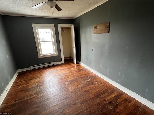 spare room with ceiling fan, dark hardwood / wood-style flooring, a textured ceiling, and a baseboard heating unit