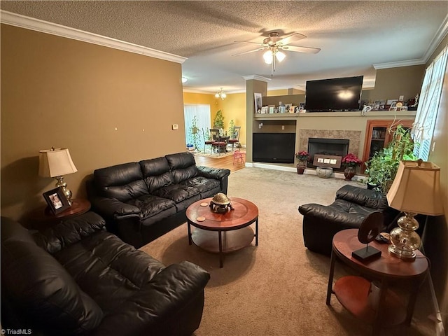 carpeted living area with a ceiling fan, a textured ceiling, ornamental molding, plenty of natural light, and a tiled fireplace