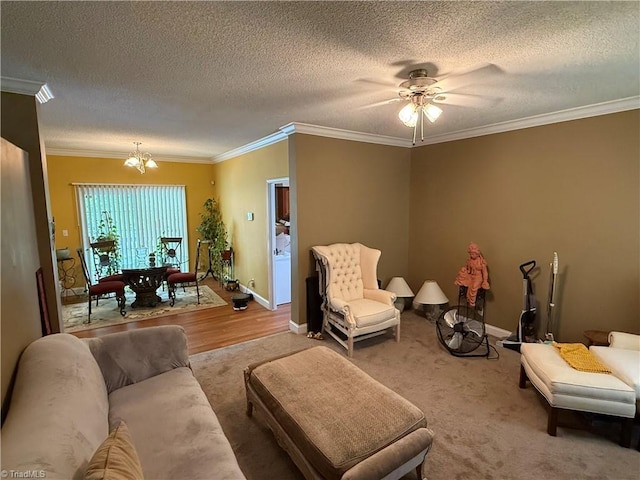 living room with a chandelier, ornamental molding, a textured ceiling, a ceiling fan, and baseboards