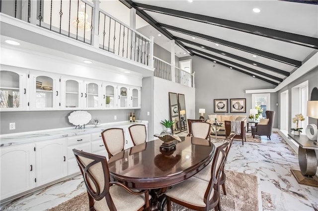 dining room with high vaulted ceiling and beamed ceiling