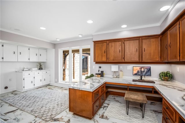 kitchen featuring white cabinetry, crown molding, built in desk, and kitchen peninsula