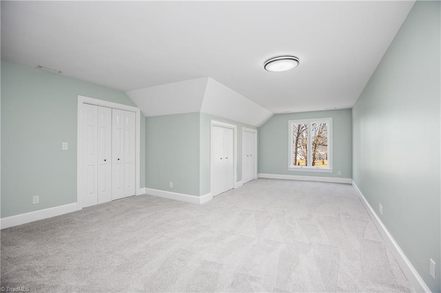 bonus room featuring vaulted ceiling and light carpet