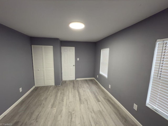 unfurnished bedroom with light hardwood / wood-style floors and a closet