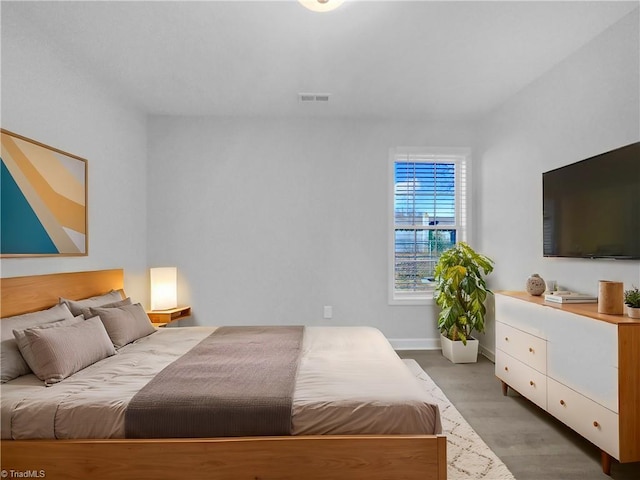 bedroom featuring visible vents, baseboards, and wood finished floors