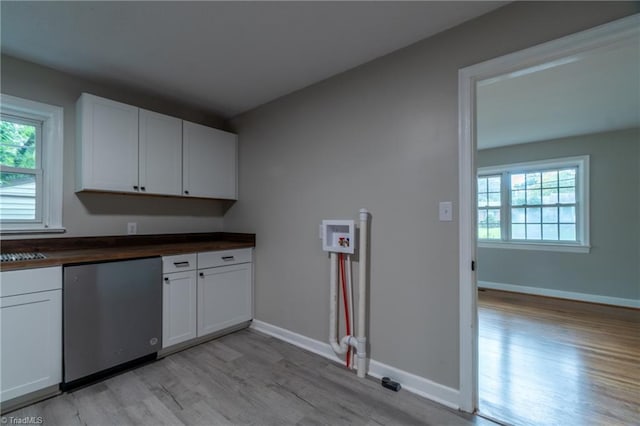 kitchen with dishwasher, white cabinets, sink, light hardwood / wood-style flooring, and butcher block counters