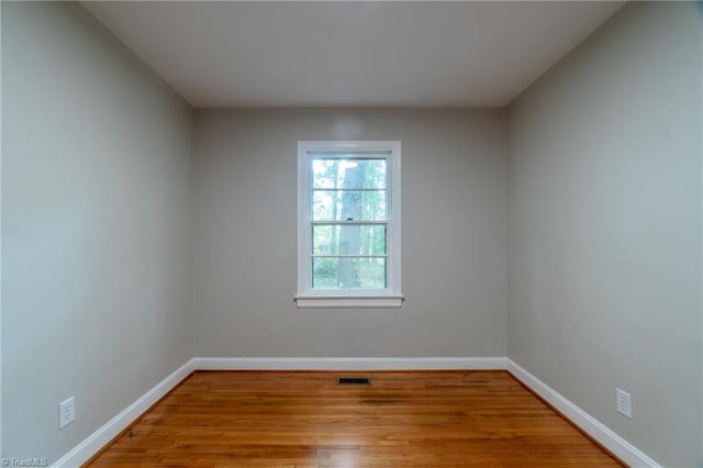 unfurnished room with hardwood / wood-style flooring