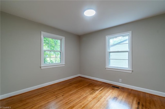 unfurnished room featuring plenty of natural light and light hardwood / wood-style flooring