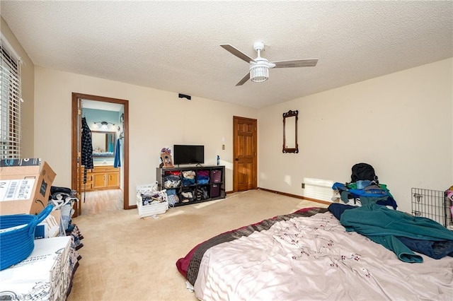 carpeted bedroom with connected bathroom, ceiling fan, and a textured ceiling