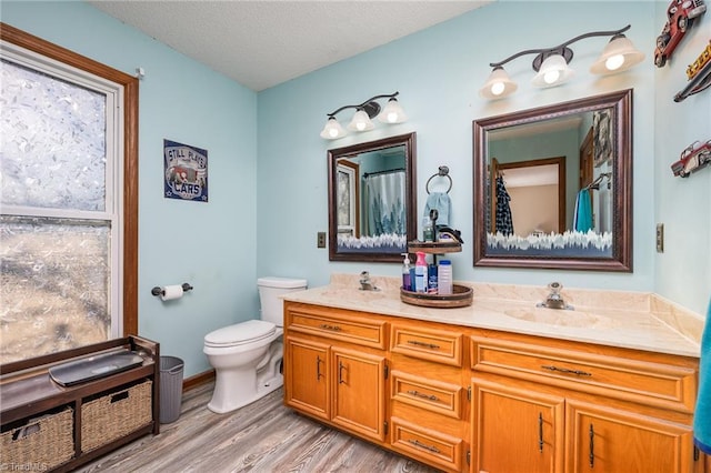 bathroom featuring hardwood / wood-style flooring, vanity, a textured ceiling, and toilet