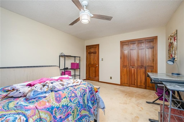 bedroom featuring ceiling fan, a closet, light carpet, and a textured ceiling