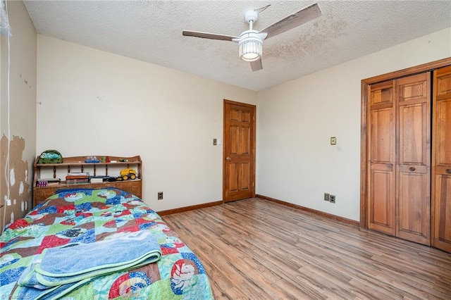 bedroom featuring ceiling fan, a textured ceiling, a closet, and light wood-type flooring