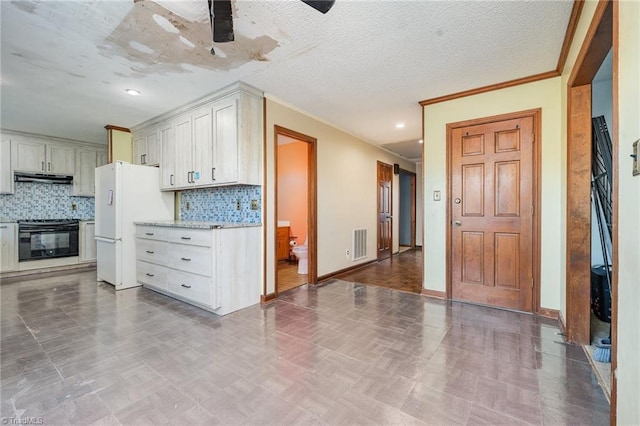 kitchen featuring white cabinetry, stove, white fridge, and ceiling fan