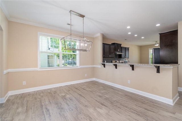 2209 Starfall Dr, Colfax, NC 27235 - kitchen featuring a kitchen breakfast bar, recessed lighting, a peninsula, ornamental molding, and light wood-type flooring