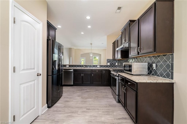 2209 Starfall Dr, Colfax, NC 27235 - kitchen with stainless steel appliances, dark brown cabinets, tasteful backsplash, light stone counters, and recessed lighting