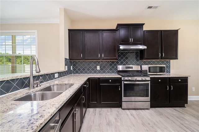 2209 Starfall Dr, Colfax, NC 27235 - kitchen featuring appliances with stainless steel finishes, under cabinet range hood, light wood-type flooring, light stone counters, and ornamental molding