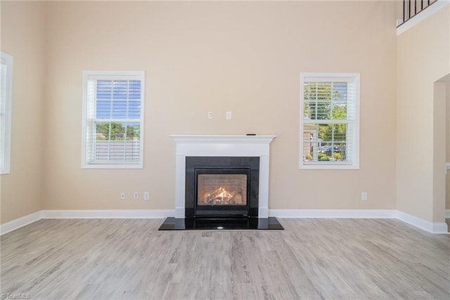 2209 Starfall Dr, Colfax, NC 27235 - unfurnished living room featuring wood finished floors and a glass covered fireplace