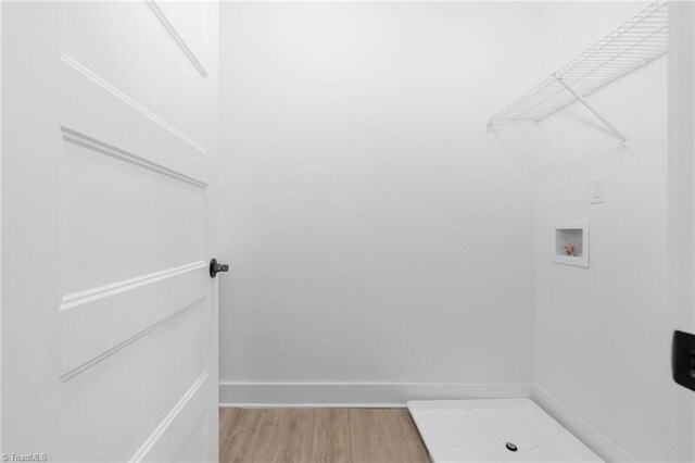 washroom featuring laundry area, baseboards, washer hookup, and light wood finished floors