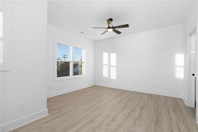 empty room featuring light wood-style floors, ceiling fan, and baseboards