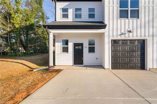 property entrance featuring board and batten siding and an attached garage