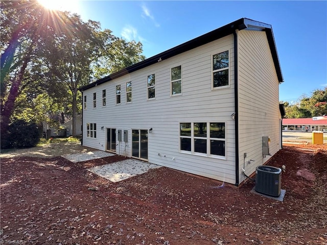 back of property with central AC unit and a patio area