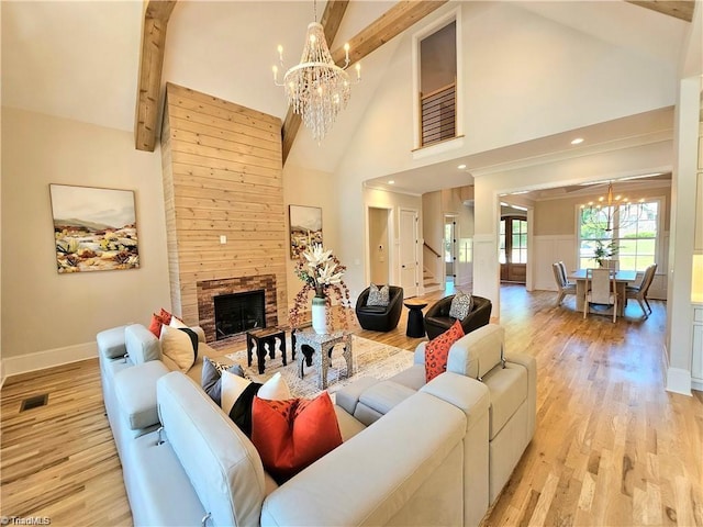 LOT121 N Holden Rd, Greensboro, NC 27410 - living room featuring a chandelier, high vaulted ceiling, beamed ceiling, a stone fireplace, and light wood-style floors