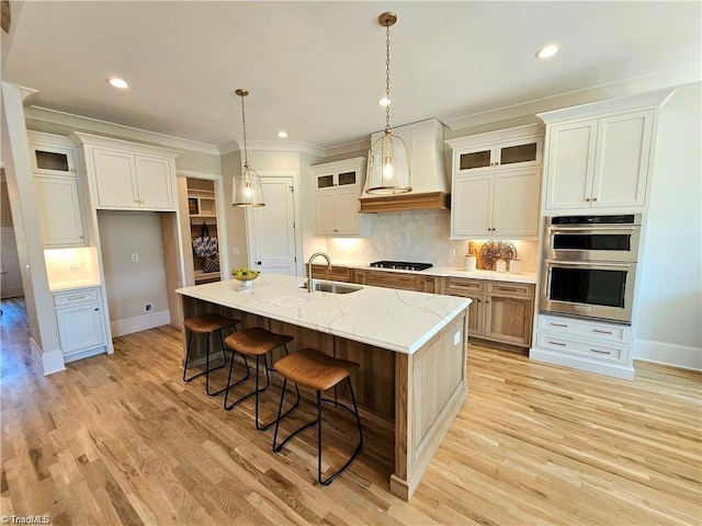 LOT121 N Holden Rd, Greensboro, NC 27410 - kitchen with stainless steel double oven, light wood-type flooring, an island with sink, crown molding, and tasteful backsplash