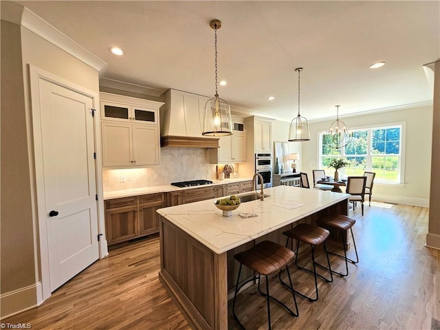 LOT121 N Holden Rd, Greensboro, NC 27410 - kitchen featuring custom range hood, wood finished floors, decorative backsplash, crown molding, and a kitchen island with sink
