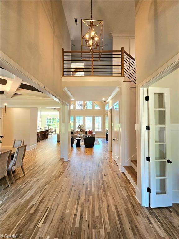 LOT121 N Holden Rd, Greensboro, NC 27410 - entryway featuring a towering ceiling, a chandelier, wood finished floors, and stairs