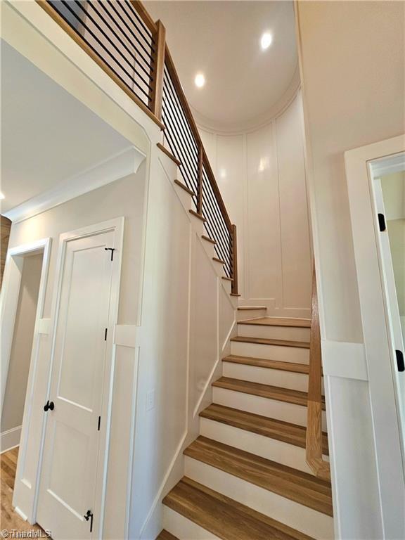 LOT121 N Holden Rd, Greensboro, NC 27410 - staircase with a decorative wall, wood finished floors, crown molding, and recessed lighting