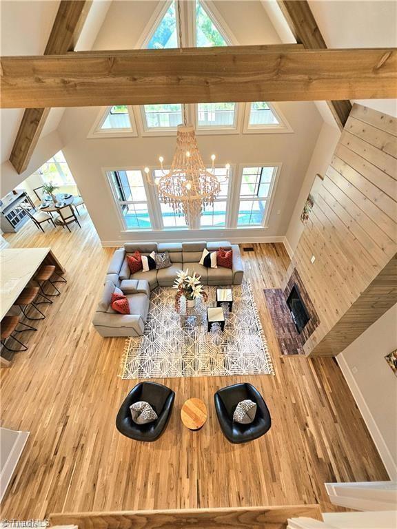 LOT121 N Holden Rd, Greensboro, NC 27410 - living room featuring plenty of natural light, beam ceiling, wood finished floors, a chandelier, and high vaulted ceiling