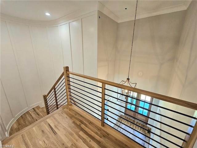 LOT121 N Holden Rd, Greensboro, NC 27410 - stairway featuring a decorative wall, wood finished floors, a chandelier, and crown molding