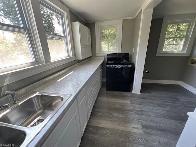 kitchen featuring sink, black / electric stove, dark hardwood / wood-style floors, a healthy amount of sunlight, and white cabinets