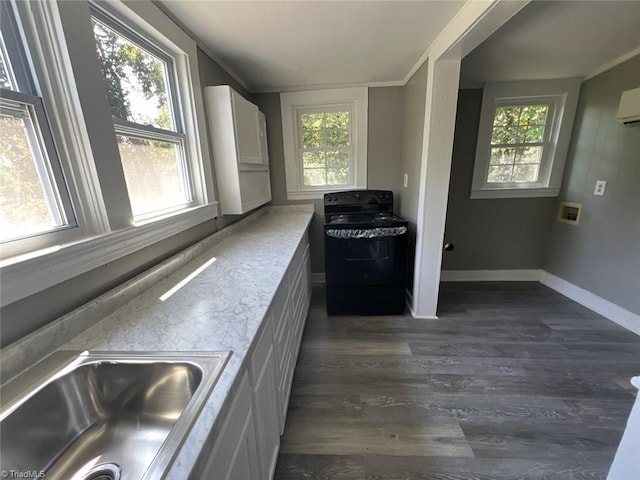 kitchen featuring black stove, dark wood-type flooring, white cabinetry, sink, and a wall mounted AC