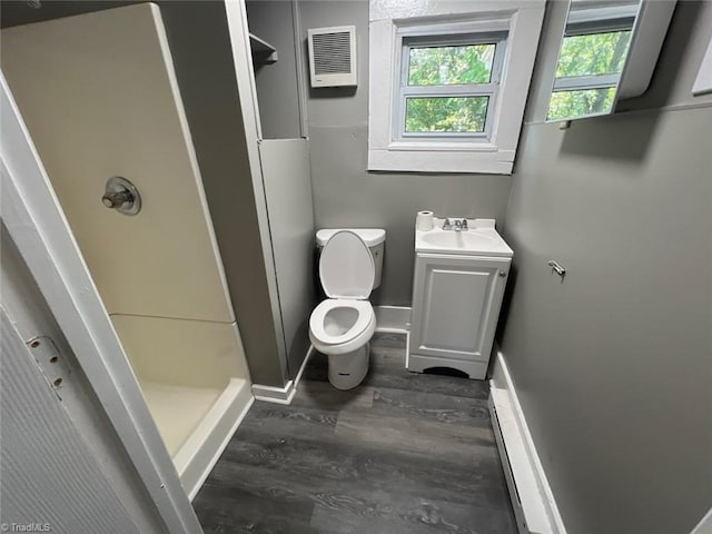 bathroom featuring toilet, a shower, hardwood / wood-style flooring, and vanity