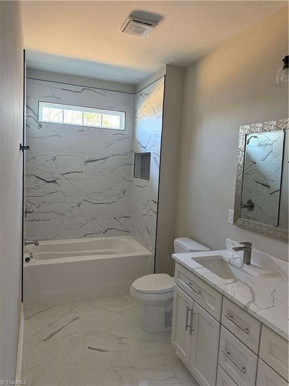 bathroom with visible vents, toilet, marble finish floor, vanity, and shower / bathtub combination