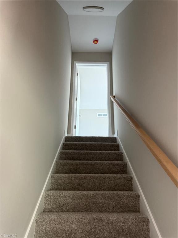 staircase featuring visible vents and baseboards