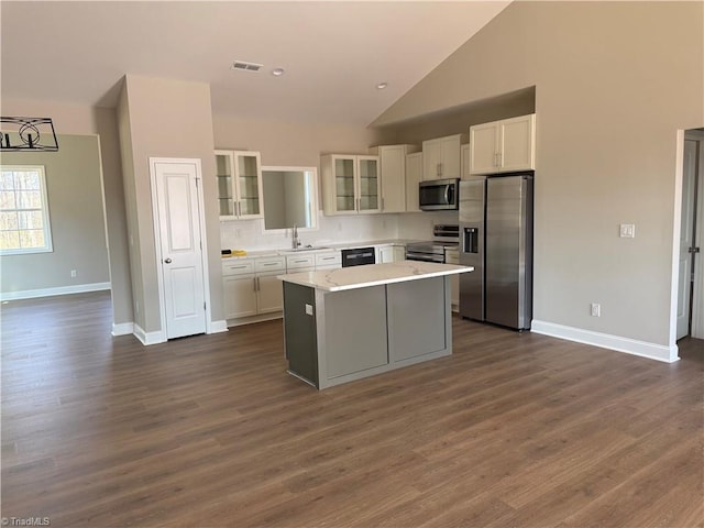 kitchen with visible vents, a kitchen island, light countertops, white cabinets, and appliances with stainless steel finishes