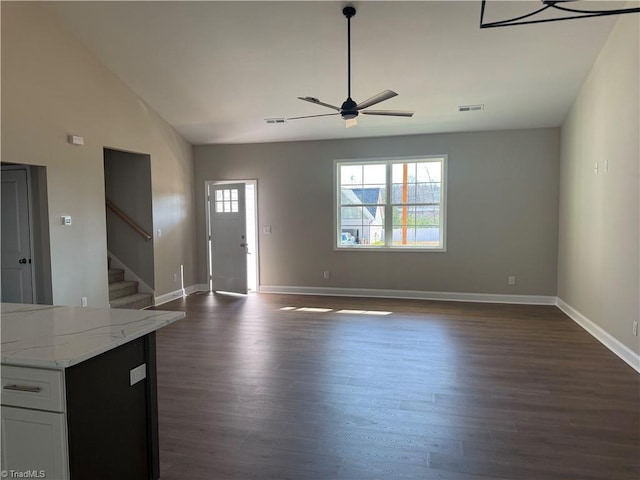 unfurnished living room featuring visible vents, dark wood-style flooring, and stairs