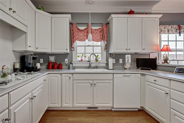 kitchen featuring white appliances, sink, pendant lighting, white cabinets, and ornamental molding